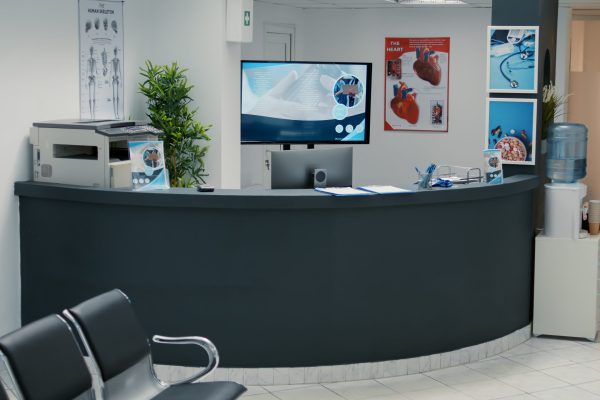 No people in empty waiting area at clinical center with reception desk, waiting room with seats to start checkup visit appointment. Medical examination with doctor at hospital lobby.